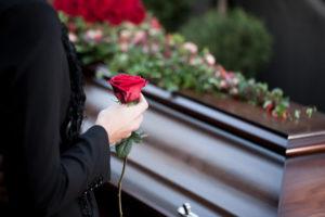 woman ready to put a rose on a coffin
