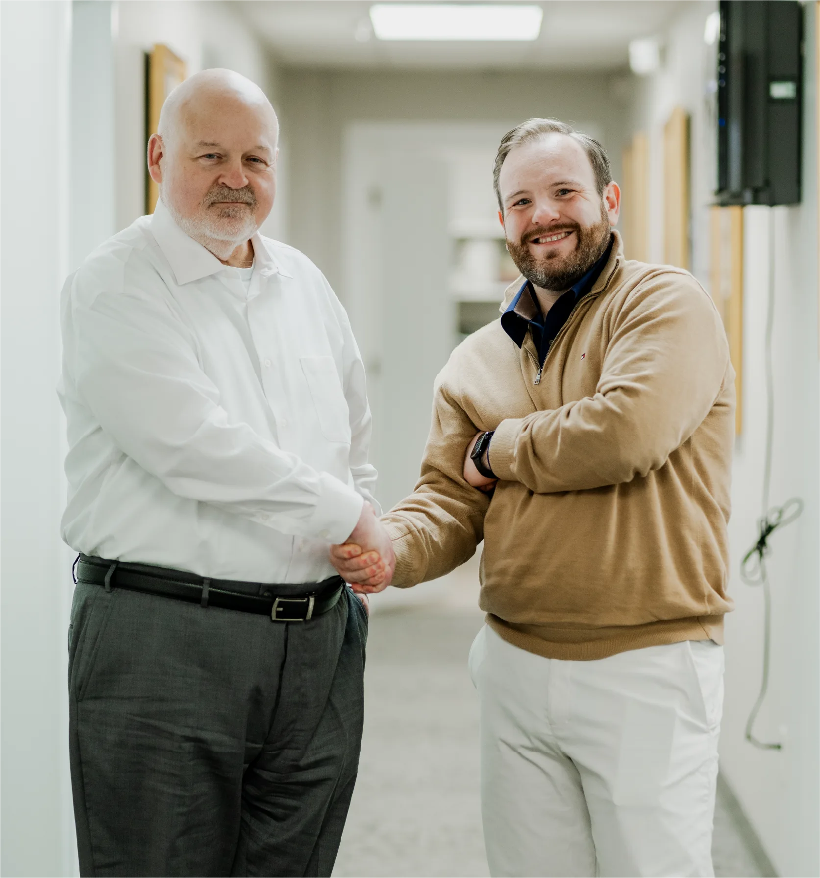 about-bressman-law Father and son attorneys shaking hands in office hallway